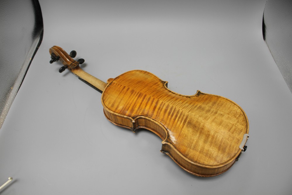 A violin with two piece back and bow, and a childs violin with bow, both with cases